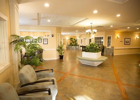 Common area with seating, indoor plants and a skylight.