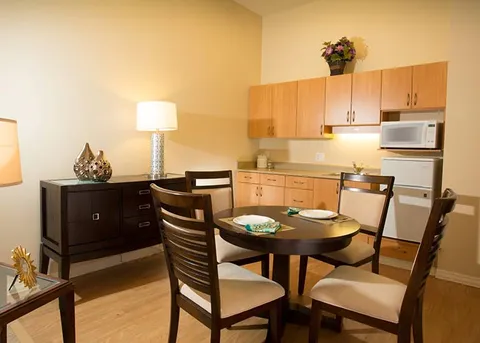 Suite kitchenette beside a small dining table and chairs.