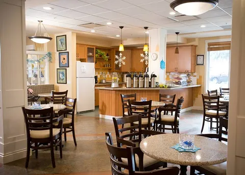 Café area with wooden tables, chairs and a service counter.