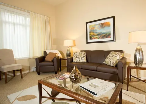 Suite living room with a sofa, armchairs and a coffee table.