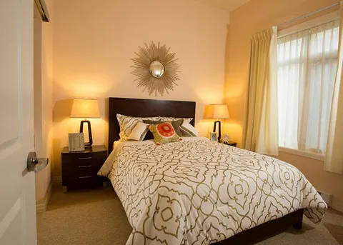 Suite bedroom with a double bed, bedside tables and a window.
