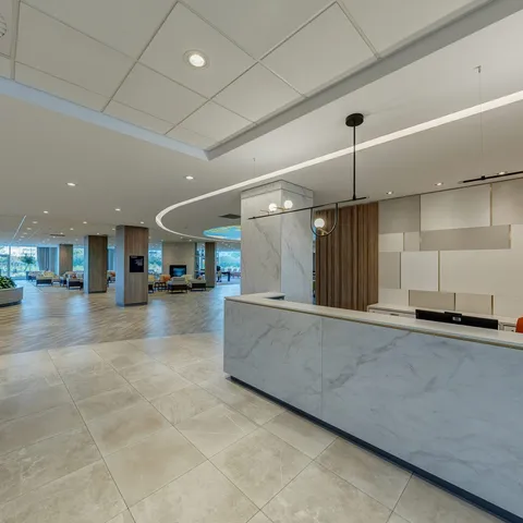 Reception counter beside a spacious lobby with seating