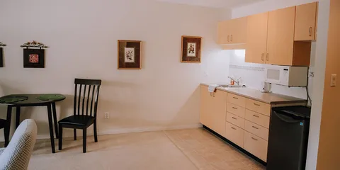 Suite dining area and kitchenette with cabinets and appliances.