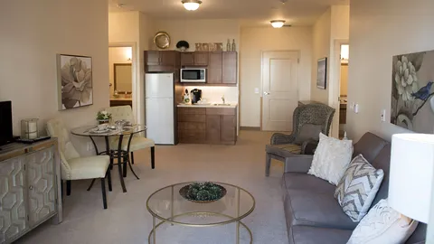 Suite sitting area and kitchenette with a sofa, round table and armchairs