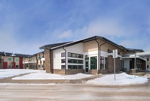 Residence exterior with a projecting entrance and snow beside the walkway