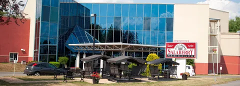 Residence exterior with a blue glass facade, covered entrance and garden swings