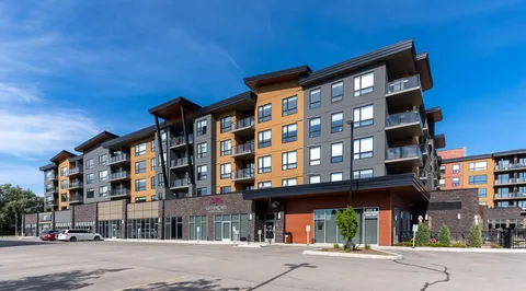 Multi-storey residence with balconies, a covered entrance and a paved parking area