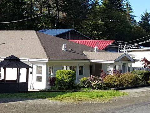Single-storey residence beside a gazebo, shrubs and paved drive