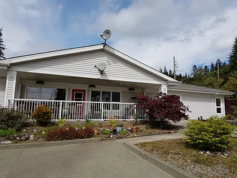 Single-storey residence with a covered porch, railings and landscaped beds