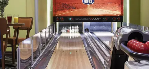 Bowling lane with a ball return and a high table beside it
