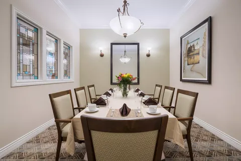 Dining table with place settings beneath a chandelier