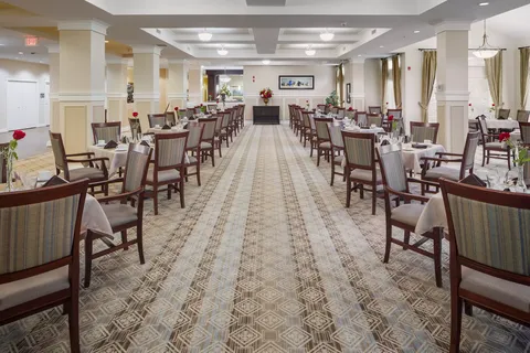 Dining room with rows of tables, upholstered chairs and patterned carpeting