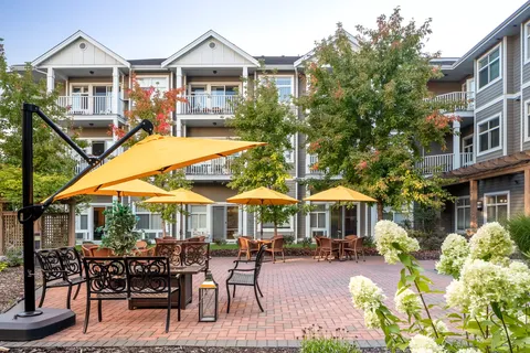 Residence around a courtyard with yellow umbrellas and flower beds