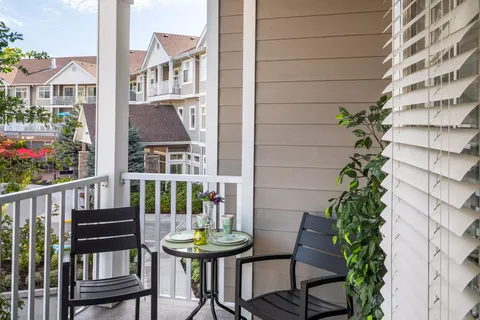 Balcony with two black chairs and a small round table