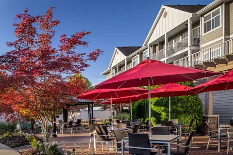 Residence balconies above a patio with red umbrellas