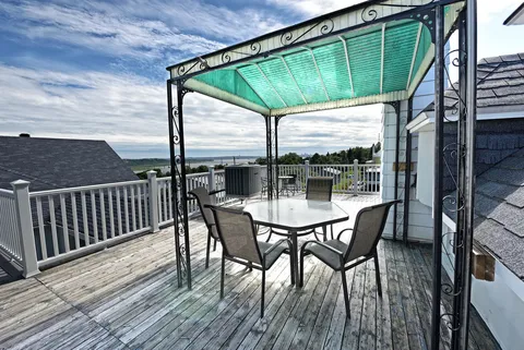 Rooftop terrace with a covered table, chairs and white railings
