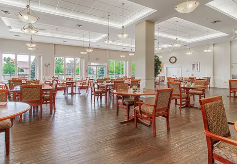 Dining room with round tables, wooden chairs and wide windows