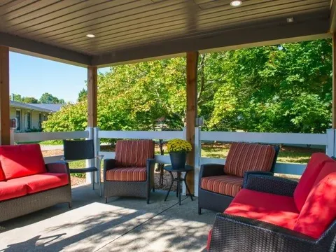 Covered patio with wicker seating and red cushions