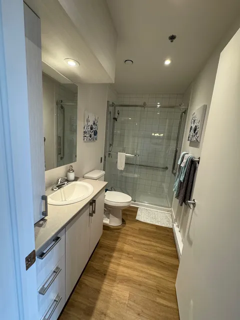 Apartment bathroom with a glass shower enclosure.