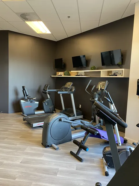 Fitness room with exercise machines and weights.