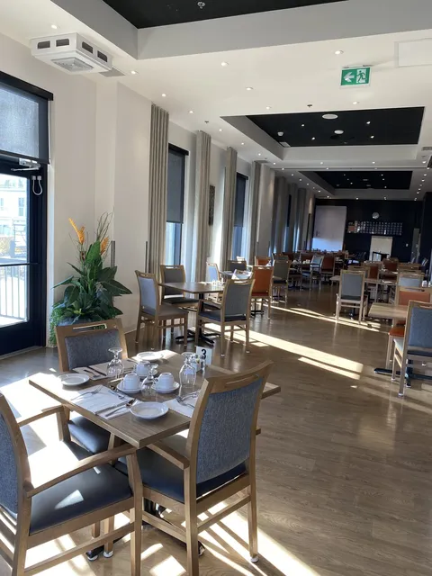 Dining room with tables beside large windows.