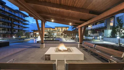 Covered courtyard seating around a fire pit at dusk.