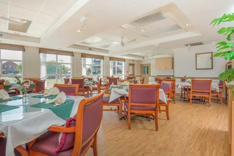 Dining room with set tables, chairs and large windows.