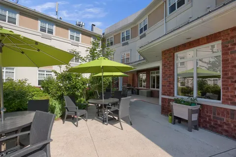 Courtyard patio with tables, green umbrellas and wicker chairs