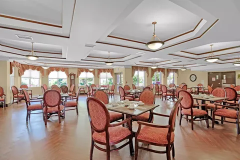 Dining room with set tables, red oval-backed chairs and pendant lights