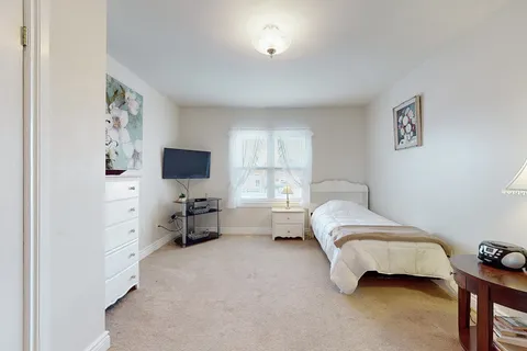 Suite bedroom with a bed, storage furniture and a window.