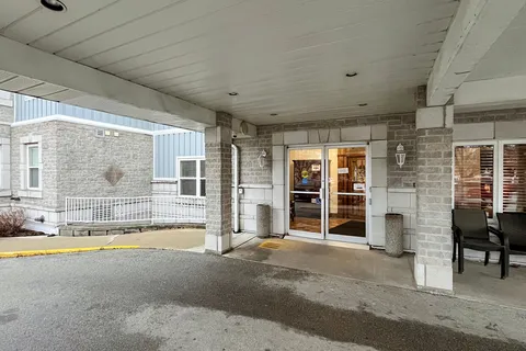 Covered entrance with glass doors and a wheelchair ramp.