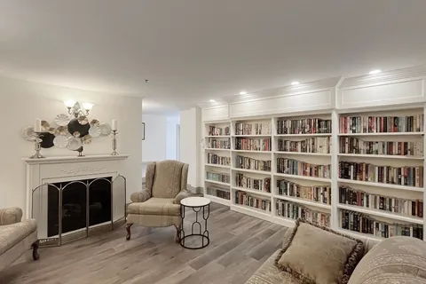 Library seating beside bookshelves and a fireplace.