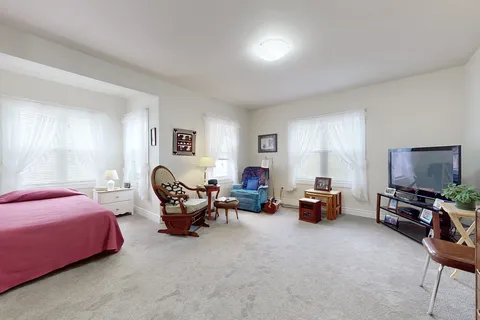 Suite with a bed and furnished sitting area.