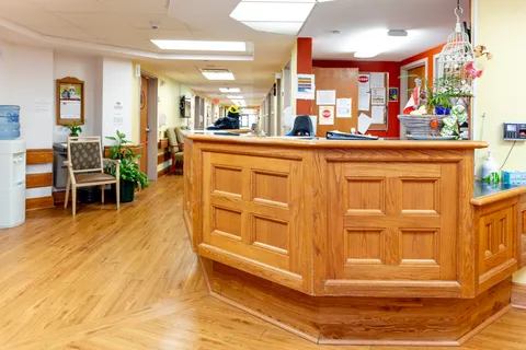Wooden reception desk beside a corridor with wood flooring