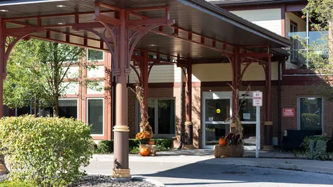 Glass entrance doors beneath a red covered walkway