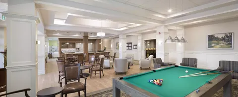 Games room with a pool table, tables and armchairs
