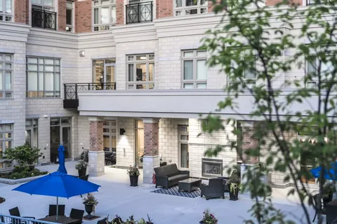 Patio with chairs, blue umbrellas and an outdoor fireplace