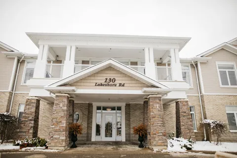 Covered front entrance with glass doors and stone columns