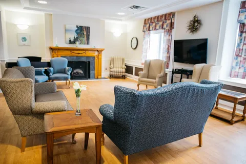 Lounge with blue armchairs and a wood fireplace surround