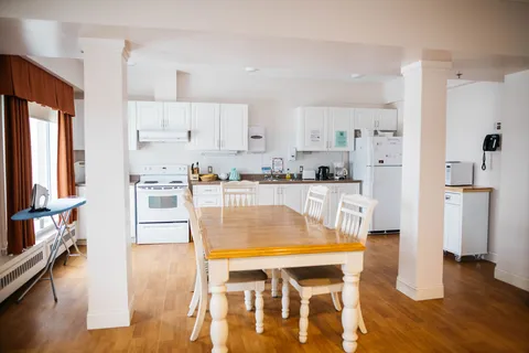 Dining table beside a bright shared kitchen