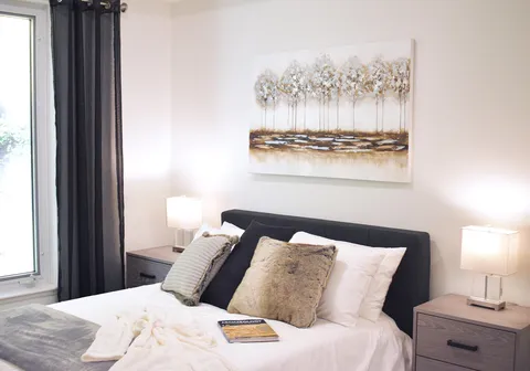 Bedroom with a double bed, bedside tables and balcony doors.