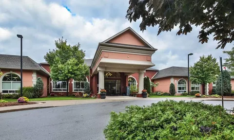 Covered entrance with driveway and flower beds