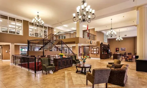Tall lobby with staircase, chandeliers and sitting areas
