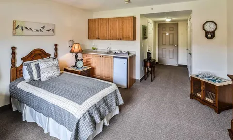Studio suite with bed and wood kitchenette cabinets