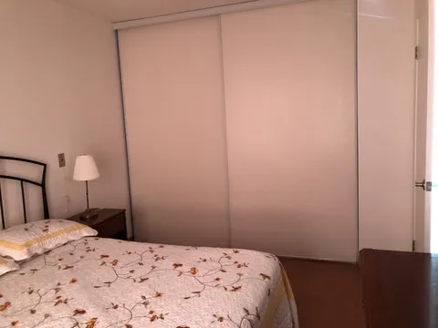 Bedroom with a floral bedspread, bedside lamp and sliding closet doors