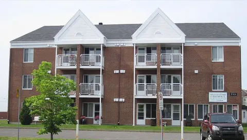 Three-storey brick residence with balconies facing the street.
