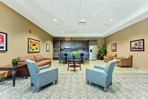 Room with armchairs, sofas and a kitchenette