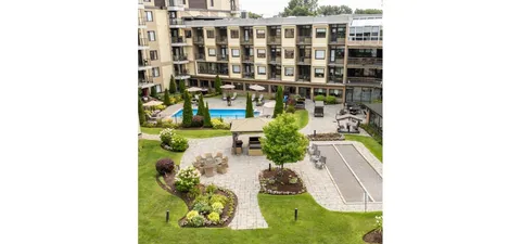Courtyard with a gazebo, seating, lawns and an outdoor pool.