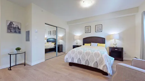 Bedroom with a bed, wooden furniture and a mirrored closet