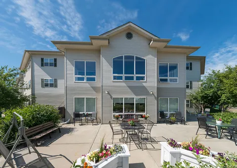 Rear building facade beside a patio with outdoor tables and chairs
